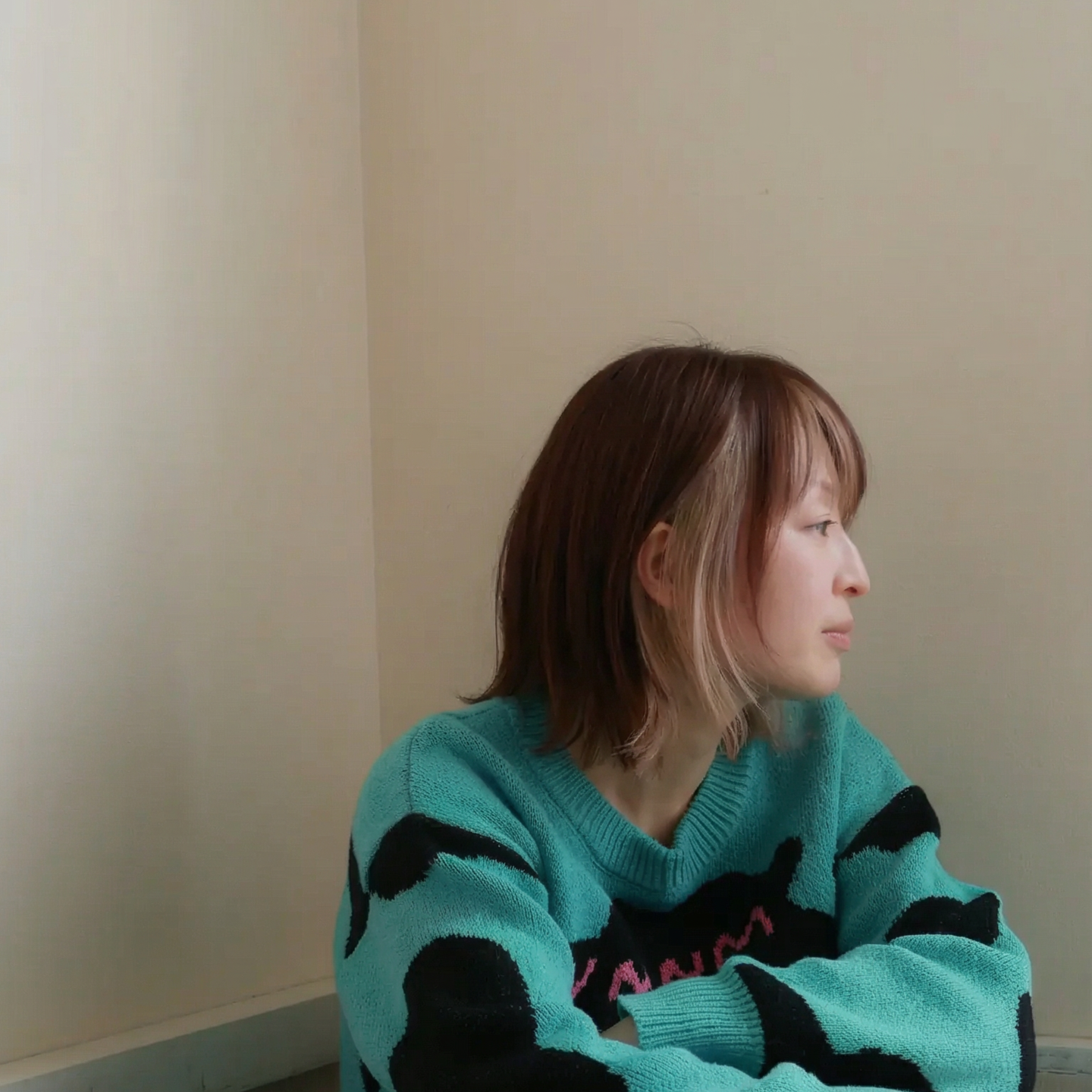 札幌市東区の美容室「ハートシェイプドボックス」のヘアスタイル作例。赤みのブラウン系ヘアカラーが美しい、ベレー帽をかぶり頬杖をつく女性のクローズアップポートレート。個性を引き出すデザインカラー。