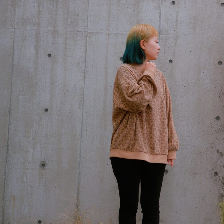 札幌市東区の美容室「ハートシェイプドボックス」のヘアスタイル作例。雪景色が広がる札幌の街角で、クリーム色のニットとチェックスカートを着て明るい笑顔を見せる女性。冬のファッションに似合うナチュラルなヘアスタイル。